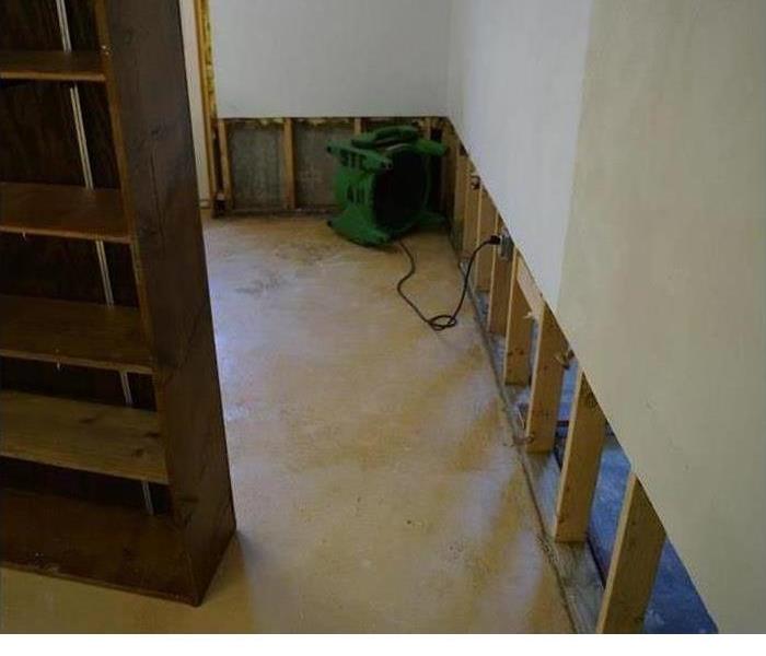 a room that has had carpet pulled up and walls started drying 