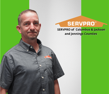 man looking at camera in a black shirt with a SERVPRO logo